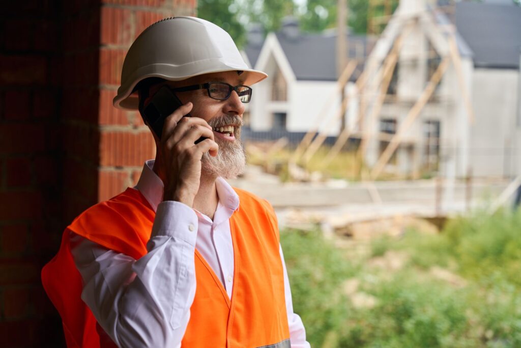 Answering service for contractors: construction foreman taking a call on a job site