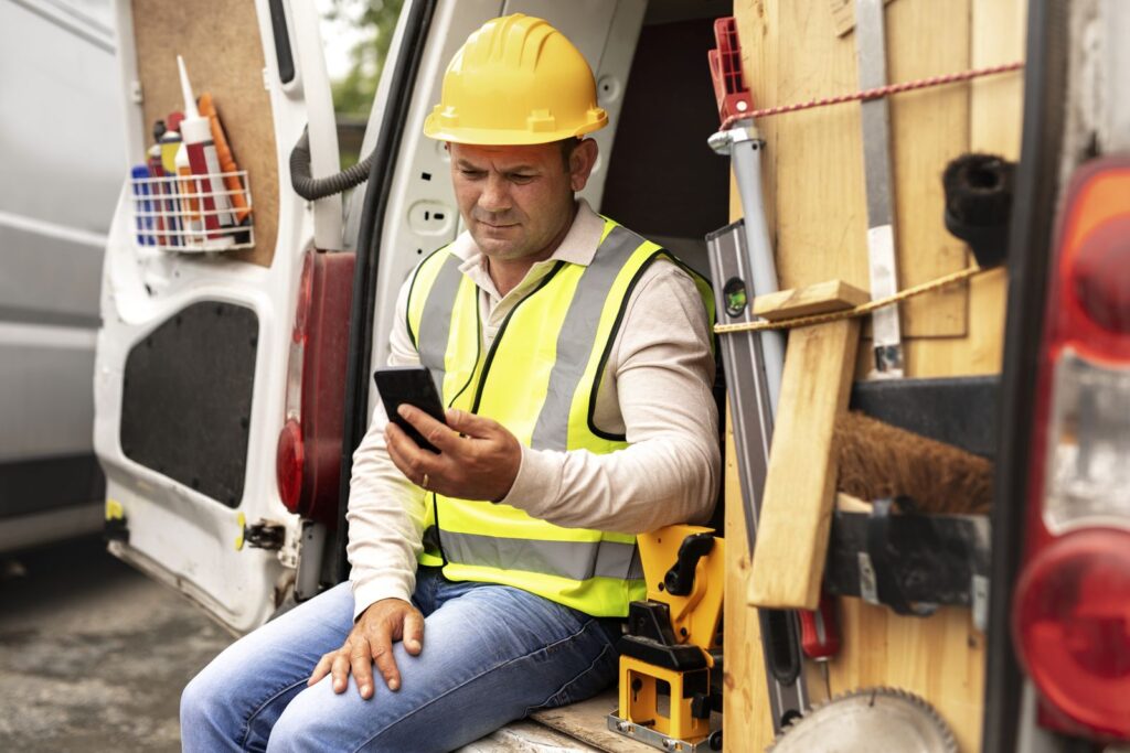 Missed call text back for contractors: contractor reading a text message in his work van