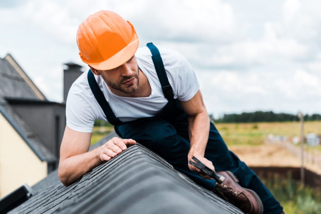 Roofing answering service for roofing contractors: roofer working on a shingle roof